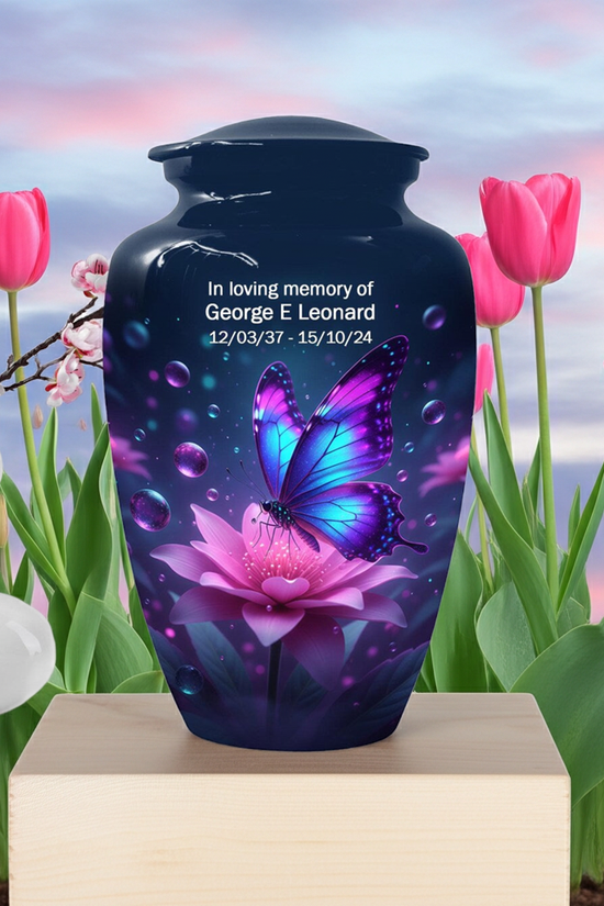 Memorial urn with butterfly and flower design in a garden setting
